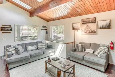 a living room with two couches and a table at 1 Mi to Lake Crestline Cabin with Deck and Gas Grill! in Crestline