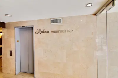 a door to a building with a sign on a wall at Rotex Western Inn in Los Angeles