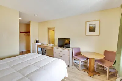 a bedroom with a bed and a desk and a television at Rotex Western Inn in Los Angeles