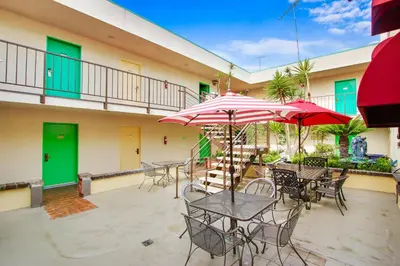 an outdoor patio with tables and chairs and umbrellas at Rotex Western Inn in Los Angeles