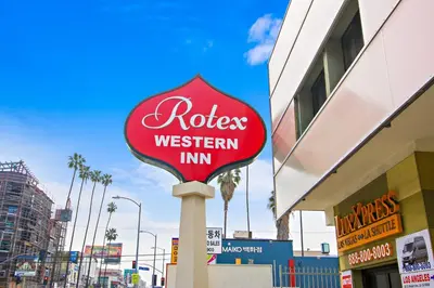 a red rosie western inn sign in front of a building at Rotex Western Inn in Los Angeles