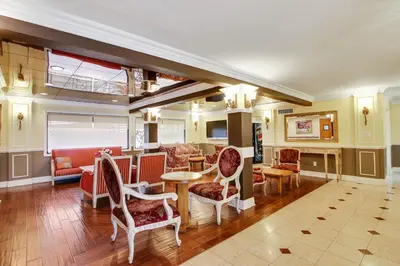 a lobby with chairs and tables and a bar at Rotex Western Inn in Los Angeles