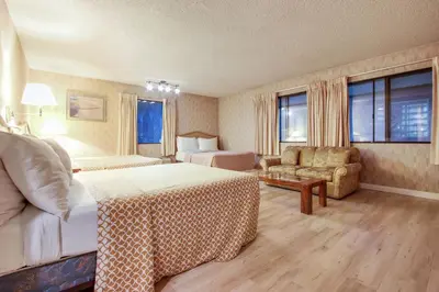 a hotel room with a bed and a chair at Rotex Western Inn in Los Angeles