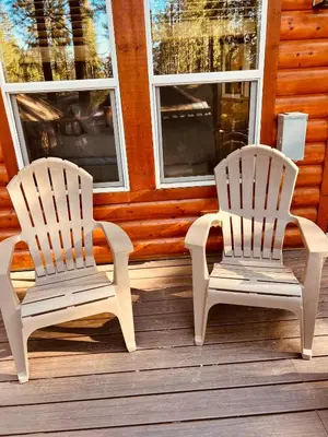 two white chairs sitting on a wooden porch at Château Bouli - 4 Season Escape and Games Room in Big Bear Lake