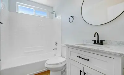 a white bathroom with a toilet and a mirror at Lancaster Pool Home in Lancaster