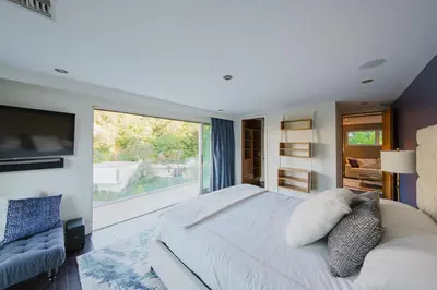 a bedroom with a large bed and a large window at Casa Azul in Los Angeles