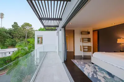 a bedroom with a bed and a glass wall at Casa Azul in Los Angeles