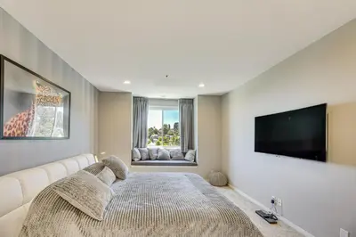 a bedroom with a large bed and a flat screen tv at 2 Mi to Hollywood Condo with Pool and Hot Tub Access in Los Angeles