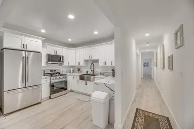 a kitchen with white cabinets and stainless steel appliances at 2 Mi to Citadel Outlets! East LA Retreat Near I-5 in Los Angeles