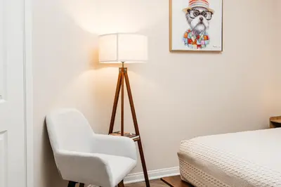 a room with a bed and a chair and a lamp at Gorgeous studio steps from The Groove in Los Angeles