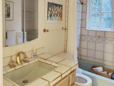 a bathroom with a tub and a toilet and a sink at Skyhill Pool - Walk to Universal - Resort-Style Home in Los Angeles