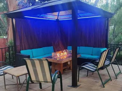 a patio with a table and chairs under a blue canopy at Skyhill Pool - Walk to Universal - Resort-Style Home in Los Angeles