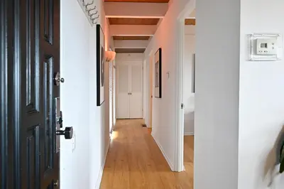a hallway with white walls and a black door at Hollywood Hills Retreat with Panoramic View in Los Angeles