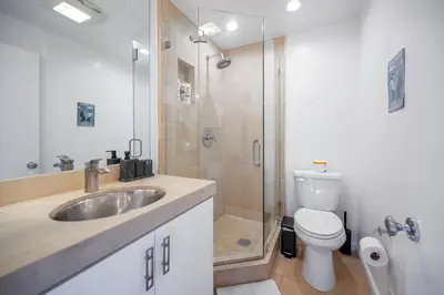 a bathroom with a sink and a toilet and a shower at Hollywood Hills Retreat with Panoramic View in Los Angeles