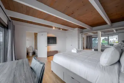 a bedroom with a large white bed and a table at Hollywood Hills Retreat with Panoramic View in Los Angeles