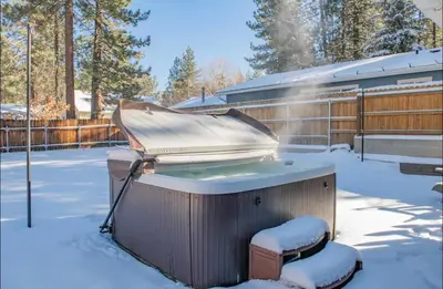 a hot tub in the snow in a yard at Family-friendly, AC, Hot Tub, Walk 2 Park & Lake in Big Bear Lake