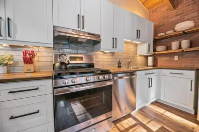 a kitchen with white cabinets and a stainless steel oven at Family-friendly, AC, Hot Tub, Walk 2 Park & Lake in Big Bear Lake