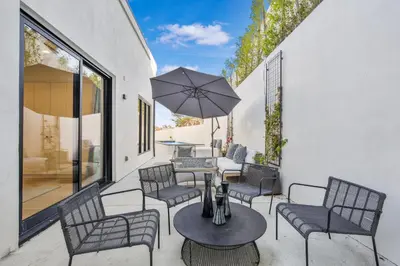 a patio with a table and chairs and an umbrella at Belden Modern Villa in Los Angeles