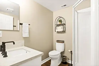 a white bathroom with a toilet and a sink at Oak Mountain Retreat, Hot Tub, & BBQ, Game Room! in Lake Arrowhead