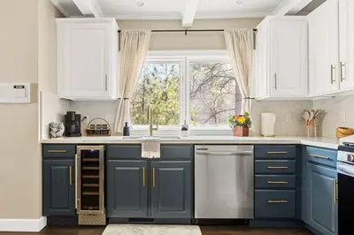 a kitchen with blue cabinets and a window at Oak Mountain Retreat, Hot Tub, & BBQ, Game Room! in Lake Arrowhead