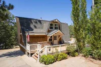 a home with a wrap around porch with a deck at Scout's Lakehouse Retreat by Colby & Conrad in Lake Arrowhead