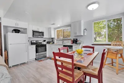 a kitchen with a table and chairs and a white refrigerator at Oasis Condo on the Fairway in Victorville