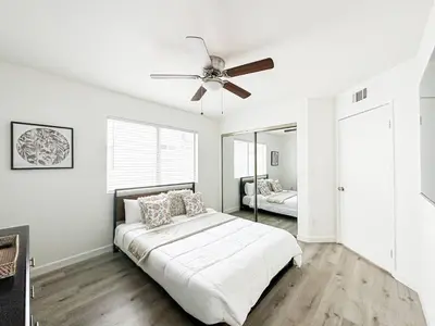 a white bedroom with a bed and a ceiling fan at Charming 2-BR, 2-Story Retreat in Heart of LA - BR4 in Los Angeles