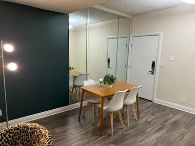 a dining room with a wooden table and white chairs at Travel Haven at Miracle Mile- 110 in Los Angeles