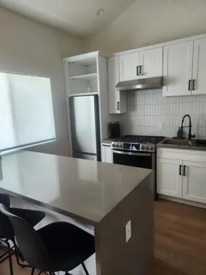 a kitchen with white cabinets and a stainless steel refrigerator at Ladera Retreat near Sofi Stadium, LAX, Beach in Los Angeles