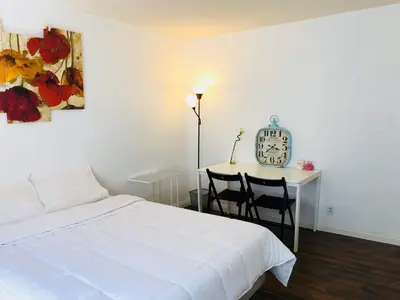 a bedroom with a bed and a table with two chairs at Coastal Comfort Homestay in Santa Monica in Los Angeles