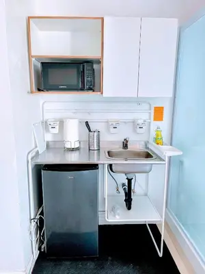 a small kitchen with a sink and a microwave at Coastal Comfort Homestay in Santa Monica in Los Angeles