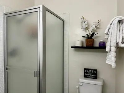 a bathroom with a toilet and a glass shower door at The Nest Manhattan Beach, Partial Ocean View in Los Angeles