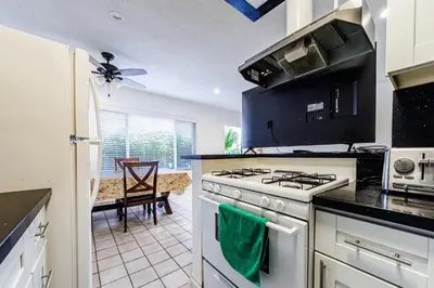 a kitchen with a stove top oven next to a table at Gorgeous 1 Bedroom Apartment#7 in Los Angeles