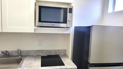 a kitchen with a microwave and a sink at MC Pacific Inn & Suites Torrance in Torrance