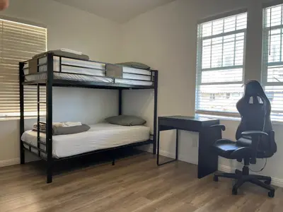 a bedroom with bunk beds and a desk and a chair at Green House in Los Angeles