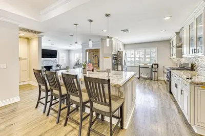 a kitchen with a large island with chairs in it at Game Room, Pool! Family Home 25 Mi to Disneyland in West Covina