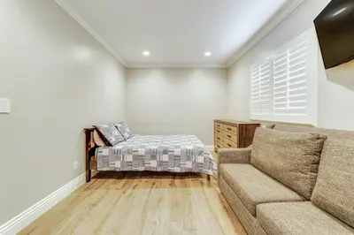 a living room with a couch and a bed at Game Room, Pool! Family Home 25 Mi to Disneyland in West Covina