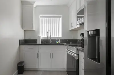 a kitchen with white cabinets and a sink and a window at Prime new beautiful studio in burbank in Burbank