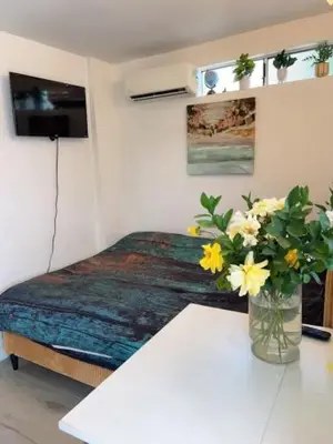a room with a bed and a table with flowers at private & Quiet unit D Bed & bath in Rosemead