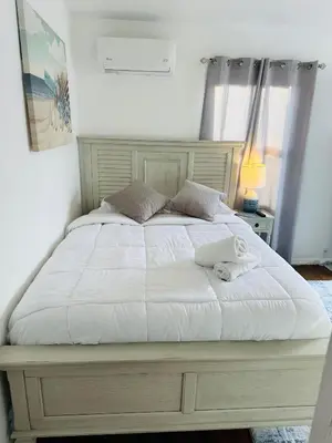 a large bed with white sheets and pillows at Studio, 5 minutes to Venice Beach Free Parking! in Los Angeles