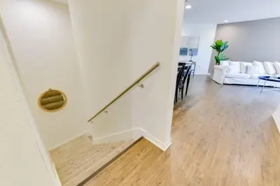 a white living room with a staircase and a couch at Lavish Living Lux Marina Views in Los Angeles