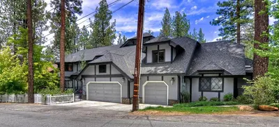 a black and white house with two garage doors at No. 8 Estate By The Lake in Big Bear Lake