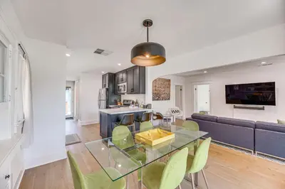 a dining room and kitchen with a glass table and chairs at 7 Mi to DTLA! Family Home with Furnished Deck in Los Angeles