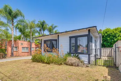 a small house with a fence in a yard at 7 Mi to DTLA! Family Home with Furnished Deck in Los Angeles