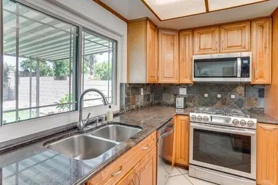 a kitchen with a sink and a microwave at Huntington Beach Home Fire Pit, Grill and More! in Huntington Beach