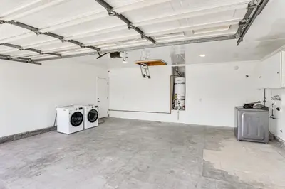 an empty room with two washing machines and a basketball hoop at Huntington Beach Home Fire Pit, Grill and More! in Huntington Beach