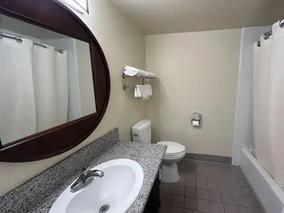 a bathroom with a sink and a toilet and a mirror at Studio 6 Suites Santa Ana, CA in Santa Ana