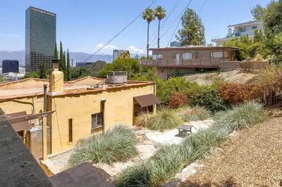 a yellow house with some tall grass on a hill at Hollywood Hills Walk to Universal City Views in Los Angeles
