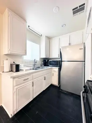a kitchen with white cabinets and a stainless steel refrigerator at Bohemian Dream- 2BR, Retreat Near Hollywood -BR6 in Los Angeles