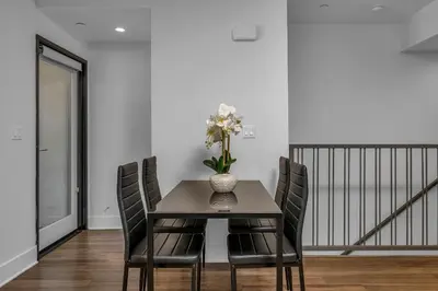 a dining room table with chairs and a vase with flowers at Amazing, Spacious Unit, Heart LA in Los Angeles